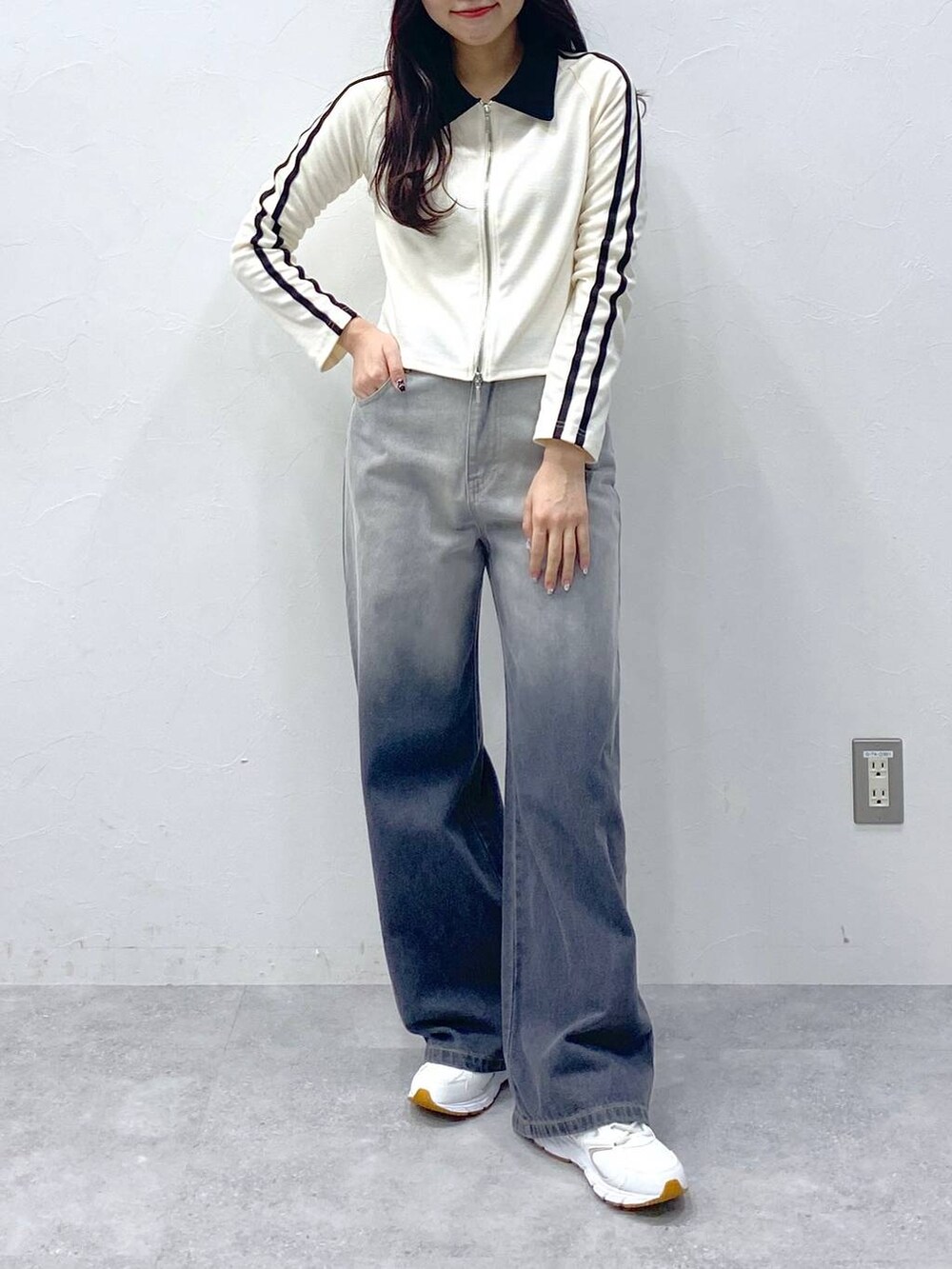 ブラック系のデニムパンツ、ベージュ系のTシャツ/カットソーを着用したレディースの春コーディネートの2枚目の写真