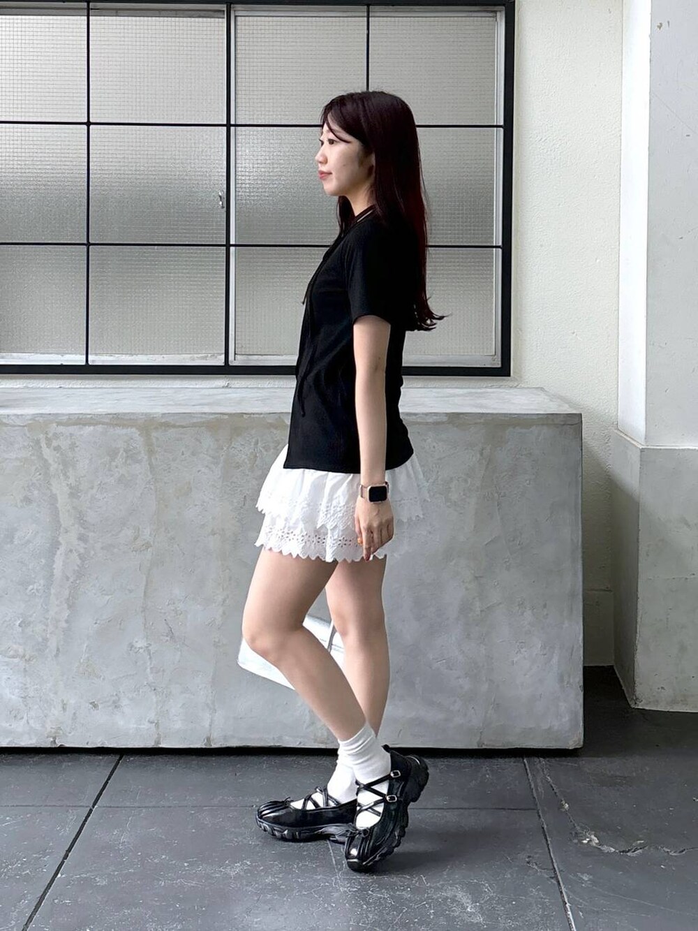 ホワイト系のスカート、ブラック系のTシャツ/カットソーを着用したレディースの夏コーディネートの3枚目の写真