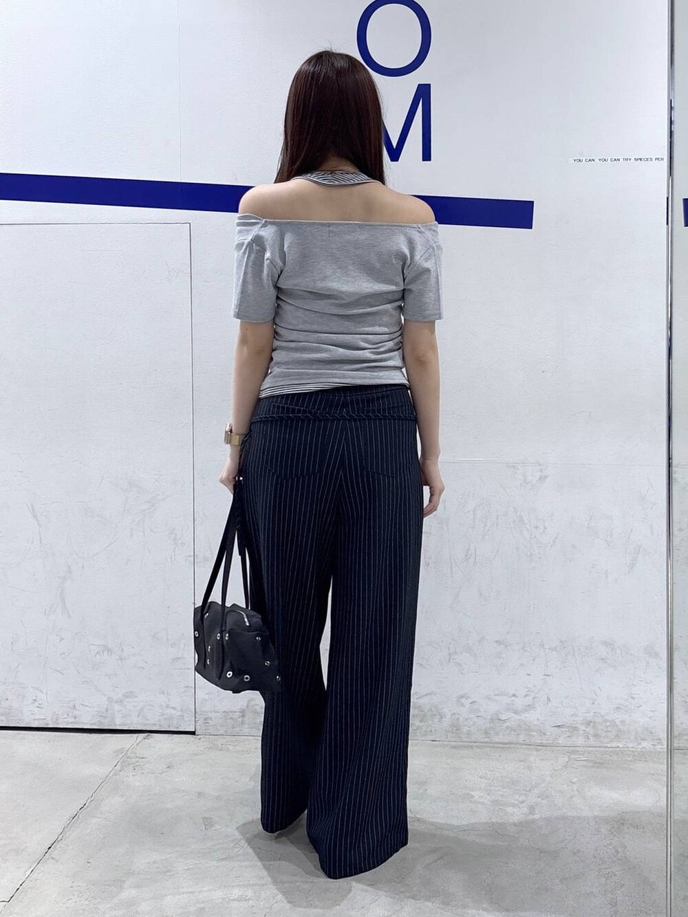 ブラック系のパンプス、グレー系のTシャツ/カットソー、ブラック系のショルダーバッグを着用したレディースの春コーディネートの4枚目の写真