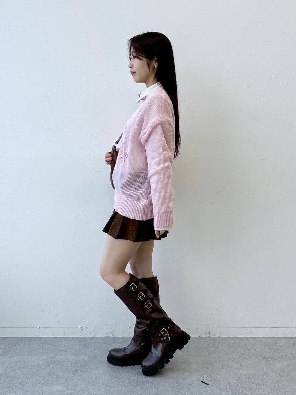 ブラウン系のブーツ、ブラウン系のスカート、ブラウン系のハンドバッグを着用したレディースの冬コーディネートの4枚目の写真