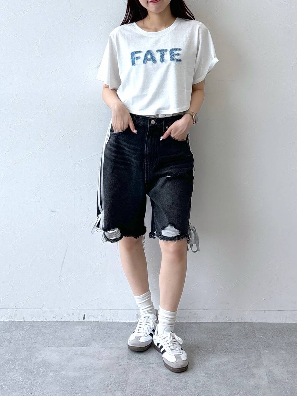 ブラック系のデニムパンツ、ホワイト系のTシャツ/カットソーを着用したレディースの夏コーディネートの2枚目の写真