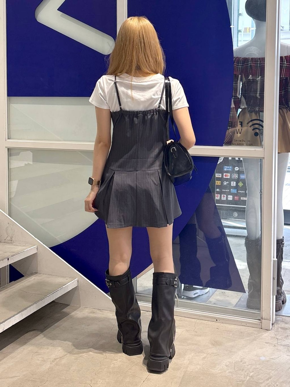 ホワイト系のTシャツ/カットソー、ブラック系のハンドバッグ、ブラック系のブーツを着用したレディースの夏コーディネートの4枚目の写真