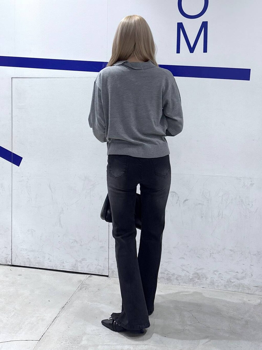 ブラック系のショルダーバッグ、ブラック系のデニムパンツ、ブラック系のパンプスを着用したレディースの冬コーディネートの4枚目の写真