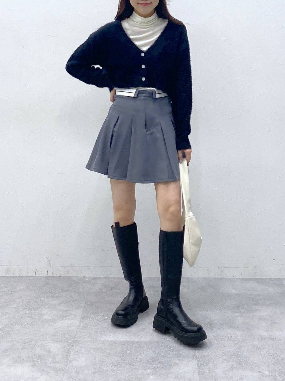 ブラック系のカーディガン/ボレロ、ベージュ系のTシャツ/カットソー、グレー系のスカートを着用したレディースの冬コーディネートの2枚目の写真