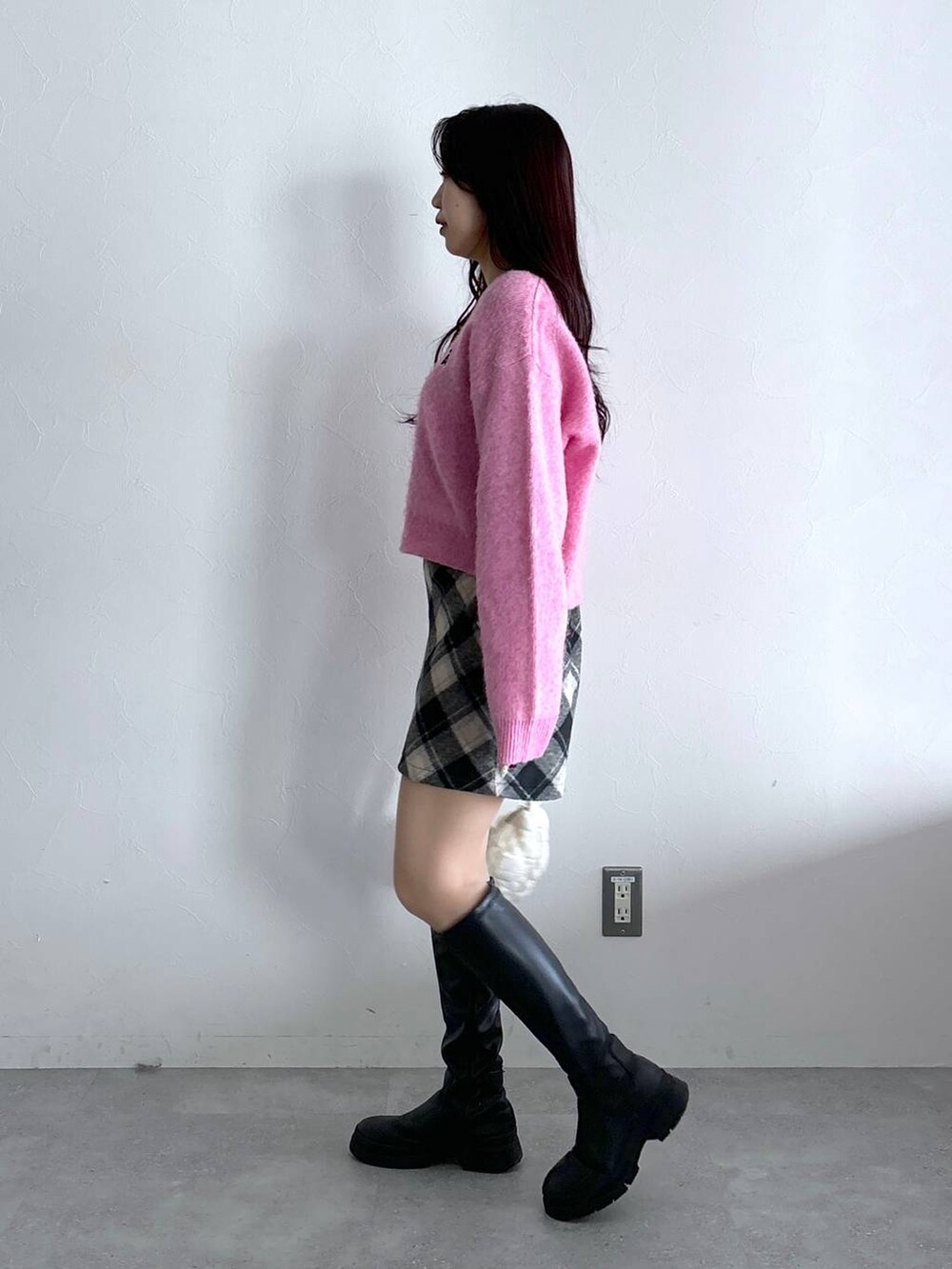 ホワイト系のショルダーバッグ、ブラック系のスカート、ピンク系のニット/セーターを着用したレディースの冬コーディネートの3枚目の写真