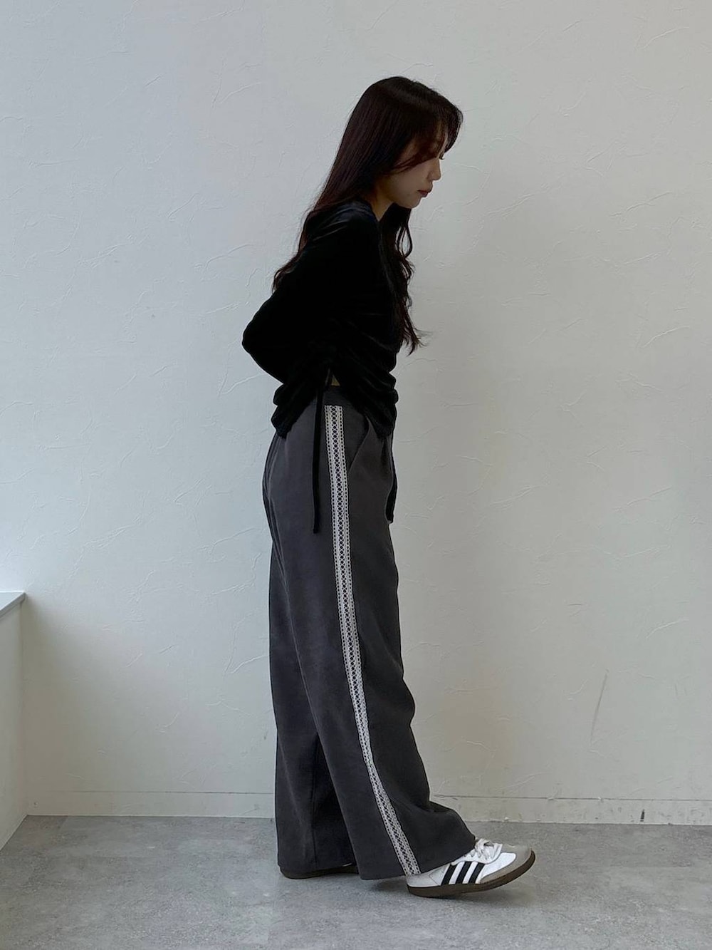 シルバー系のショルダーバッグ、グレー系のスラックス、ブラック系のTシャツ/カットソーを着用したレディースの冬コーディネートの5枚目の写真