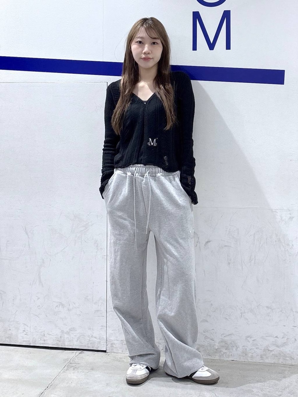 グレー系のスウェットパンツ、ブラック系のカーディガン/ボレロ、グレー系のキャップを着用したレディースの春コーディネートの2枚目の写真