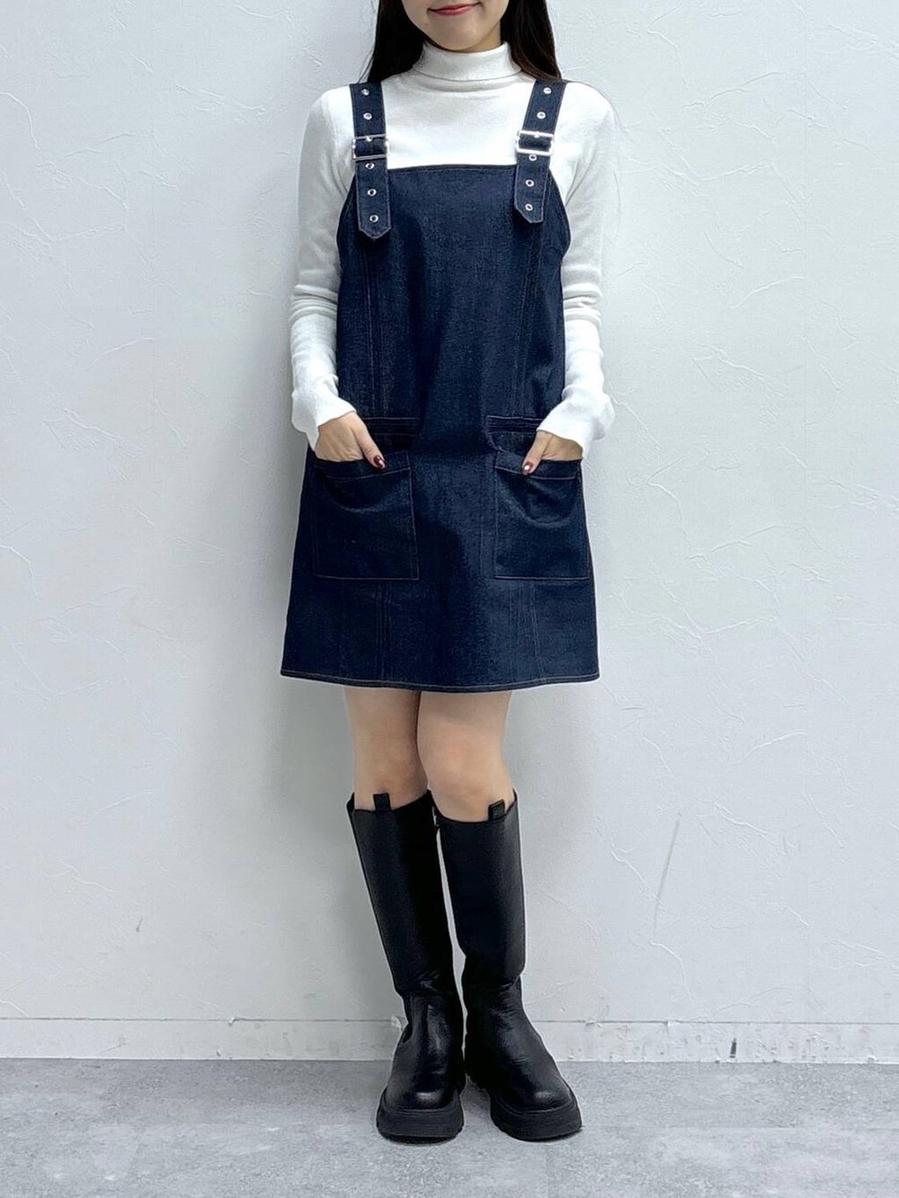 ホワイト系のニット/セーター、ブラック系のブーツを着用したレディースの冬コーディネートの2枚目の写真