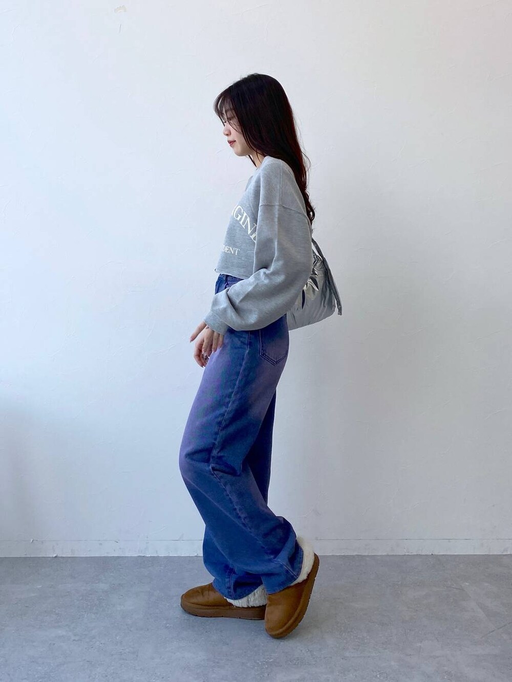 パープル系のデニムパンツ、その他のショルダーバッグ、グレー系のTシャツ/カットソーを着用したレディースの冬コーディネートの4枚目の写真