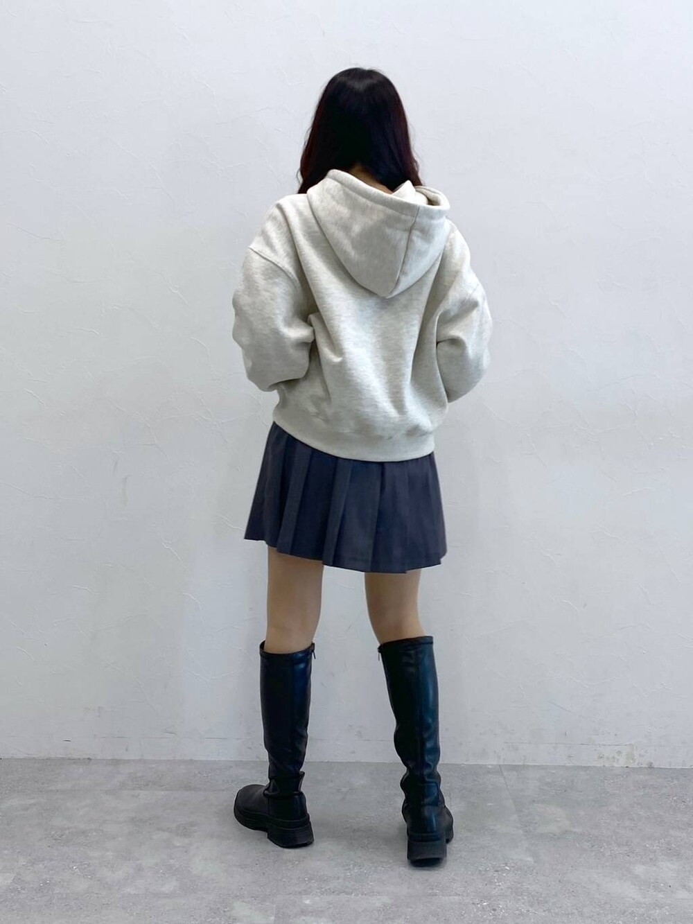 グレー系のスカート、ベージュ系のパーカーを着用したレディースの冬コーディネートの4枚目の写真