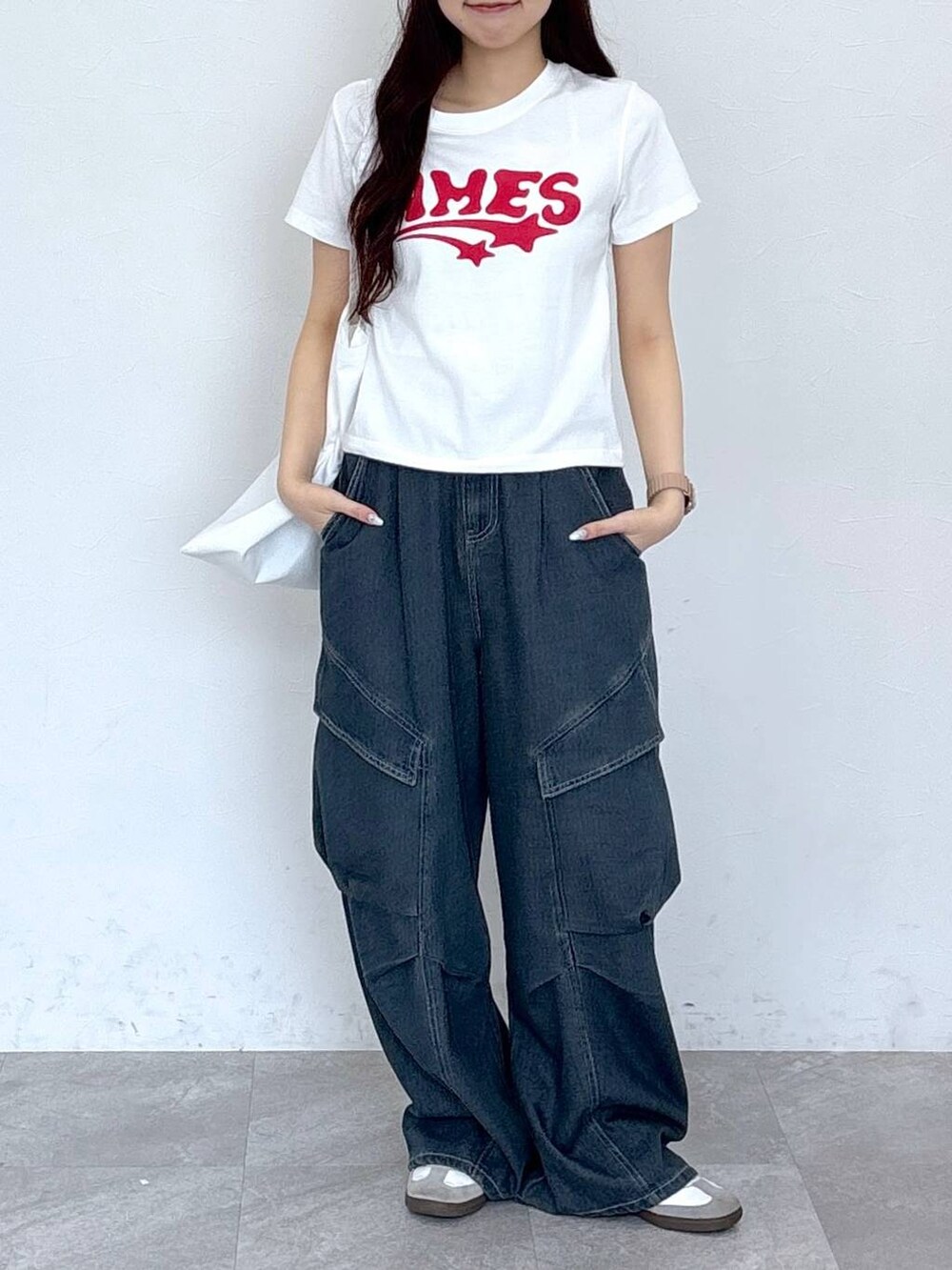 ブルー系のカーゴパンツ、その他のトートバッグ、ホワイト系のTシャツ/カットソーを着用したレディースの春コーディネートの2枚目の写真