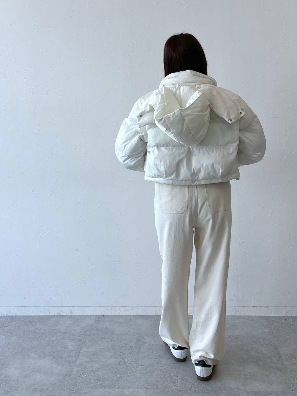 ベージュ系のダウンジャケット/コート、ホワイト系のデニムパンツ、ピンク系のTシャツ/カットソーを着用したレディースの秋コーディネートの3枚目の写真