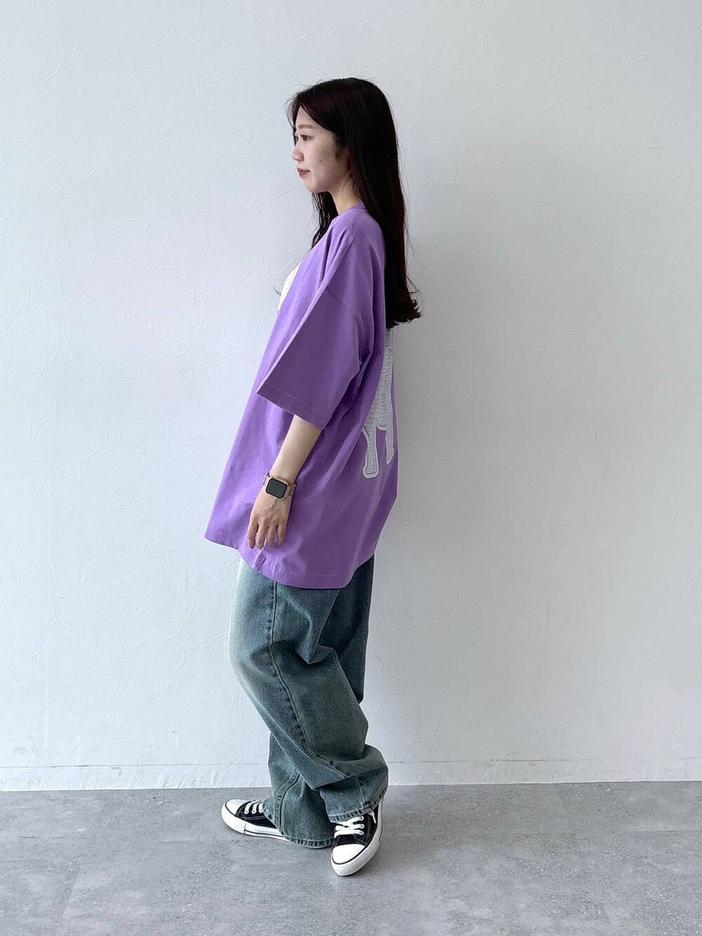 ブルー系のデニムパンツ、ブラック系のボストンバッグ、パープル系のTシャツ/カットソーを着用したレディースの夏コーディネートの3枚目の写真