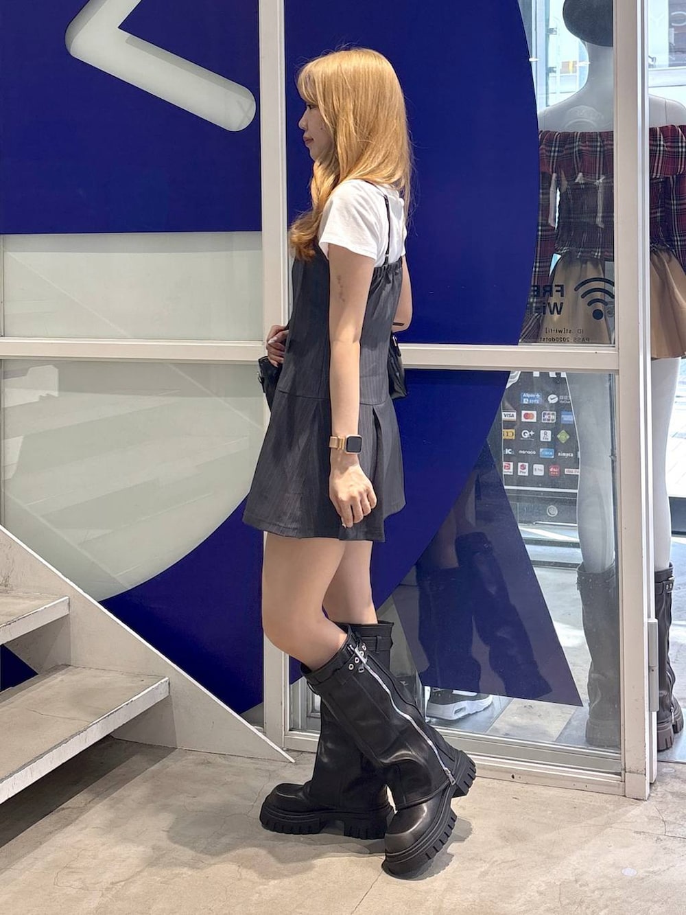 ホワイト系のTシャツ/カットソー、ブラック系のハンドバッグ、ブラック系のブーツを着用したレディースの夏コーディネートの3枚目の写真