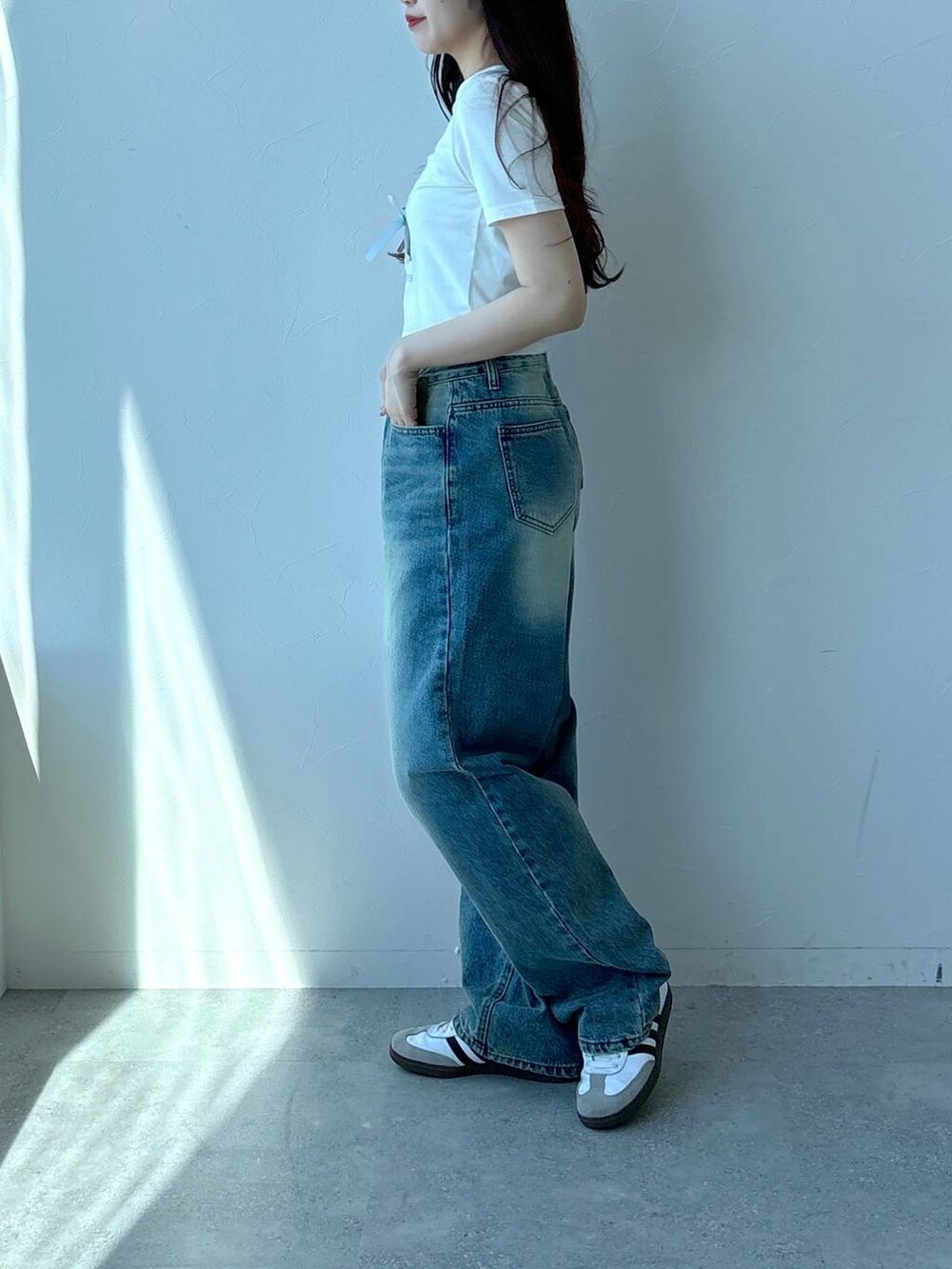 ホワイト系のTシャツ/カットソー、ブルー系のデニムパンツを着用したレディースの春コーディネートの3枚目の写真