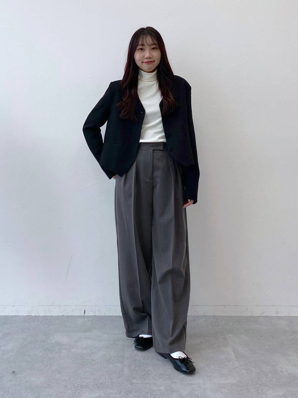 ブラック系のバレエシューズ、グレー系のスラックス、ブラック系のノーカラージャケットを着用したレディースの冬コーディネートの2枚目の写真