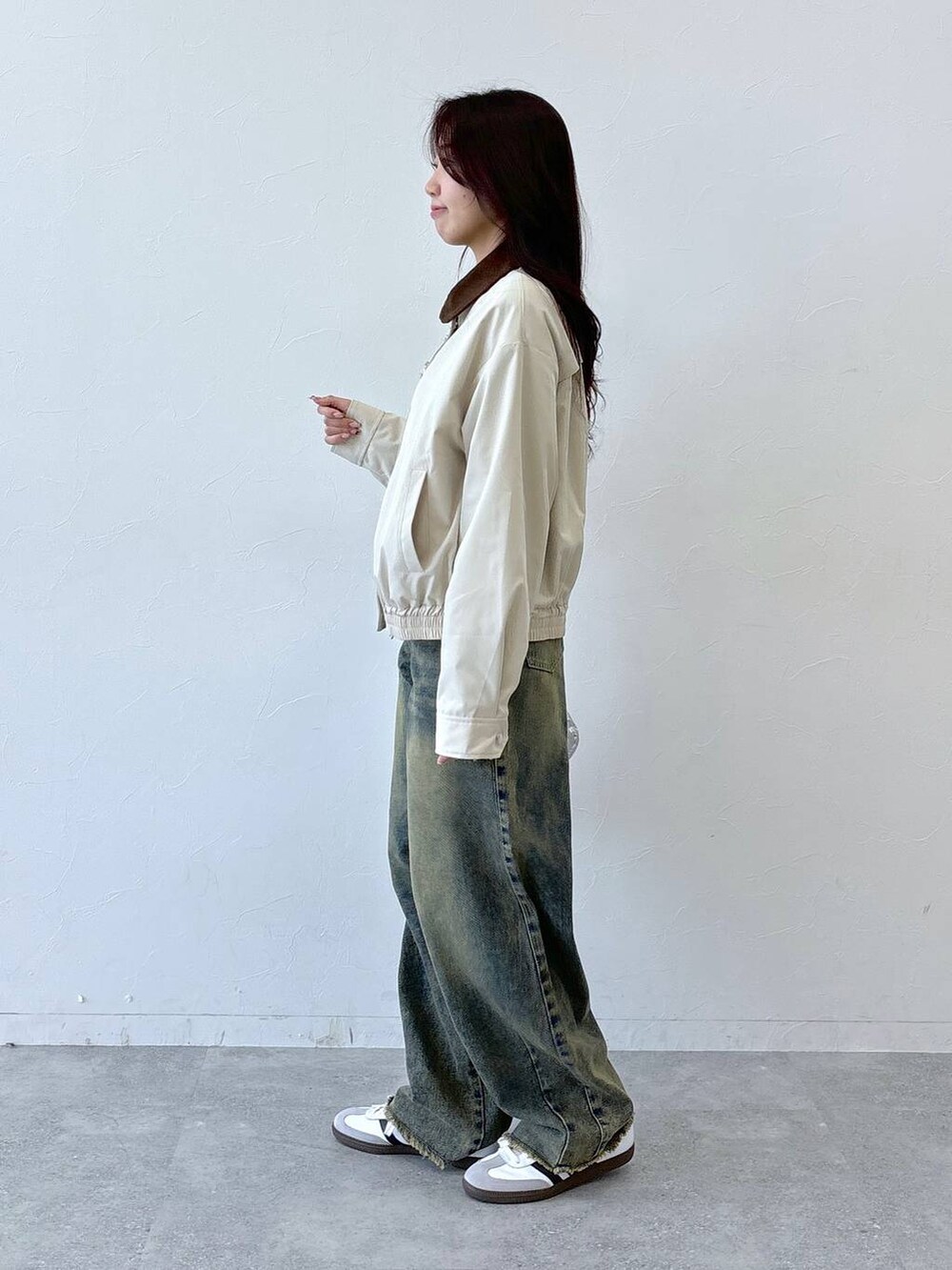 その他のショルダーバッグ、ブルー系のデニムパンツ、ホワイト系のブルゾンを着用したレディースの冬コーディネートの3枚目の写真