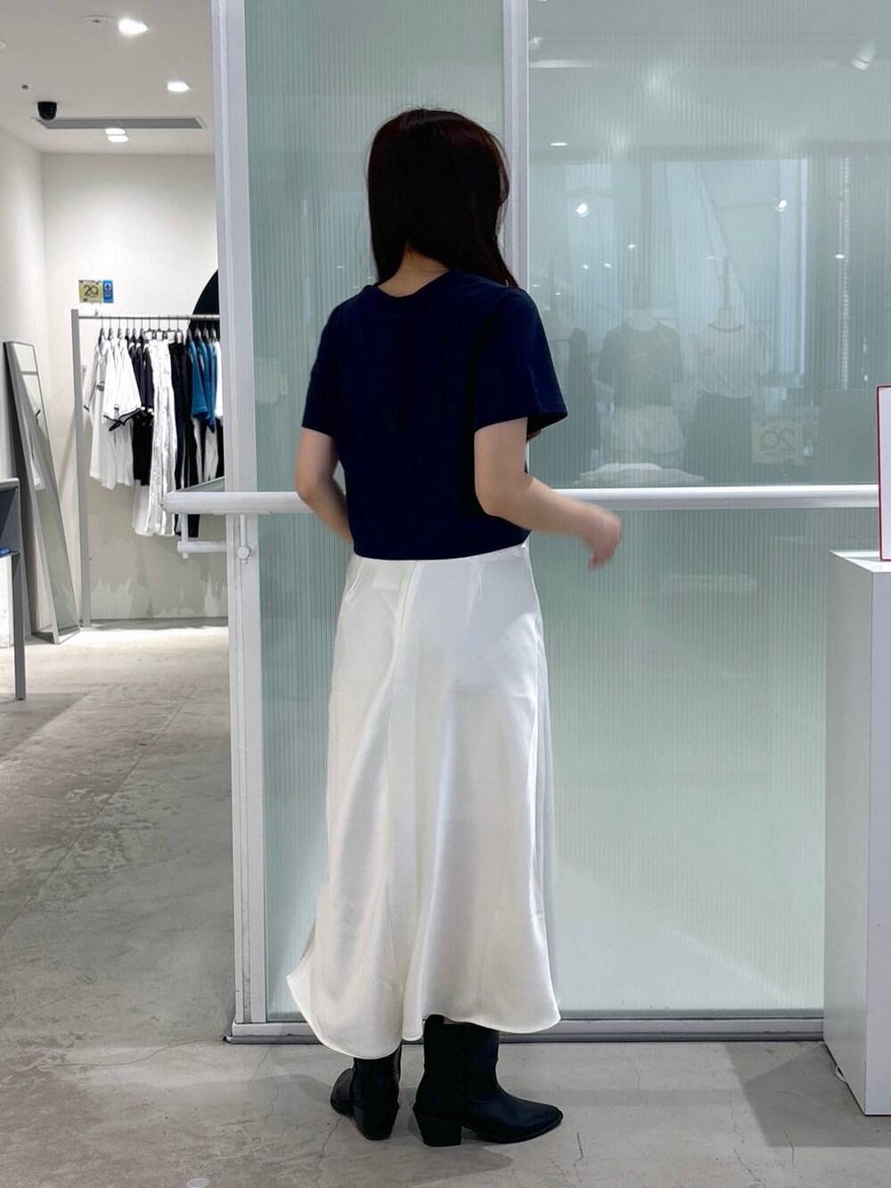 ブラック系のブーツ、ベージュ系のスカート、ブルー系のTシャツ/カットソーを着用したレディースの春コーディネートの4枚目の写真