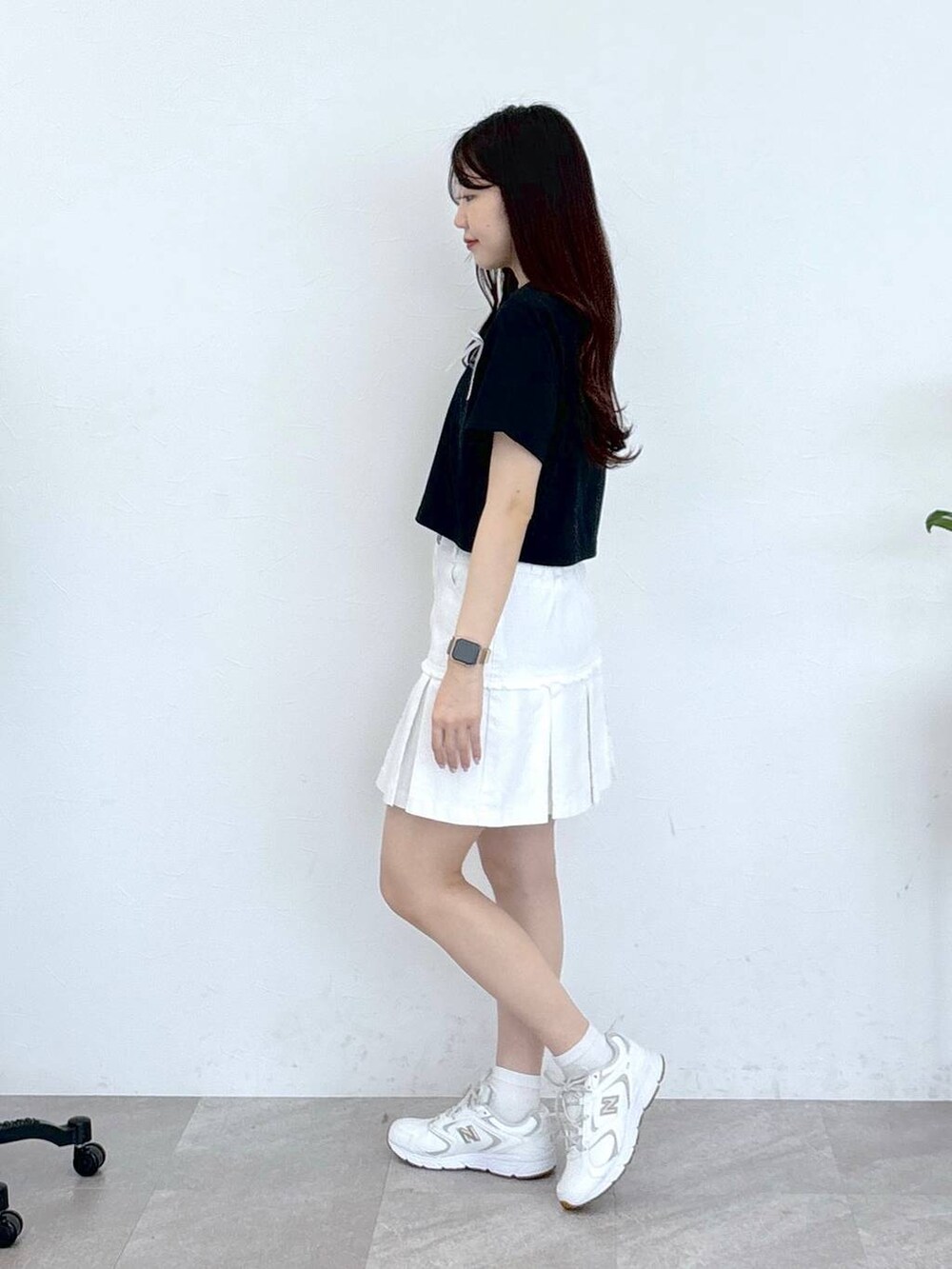 ホワイト系のデニムスカート、ブラック系のTシャツ/カットソーを着用したレディースの春コーディネートの3枚目の写真