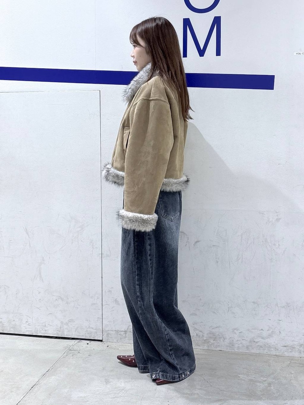 レッド系のTシャツ/カットソー、ブルー系のデニムパンツ、グレー系のムートンコートを着用したレディースの秋コーディネートの3枚目の写真