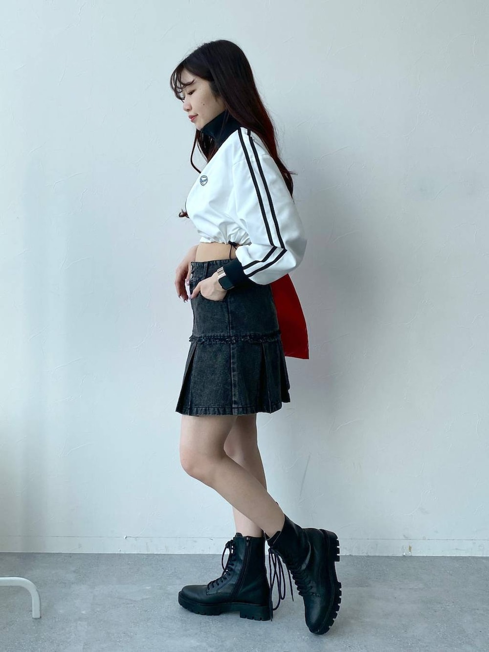 ホワイト系のブルゾン、レッド系のトートバッグ、ブラック系のデニムスカートを着用したレディースの春コーディネートの3枚目の写真