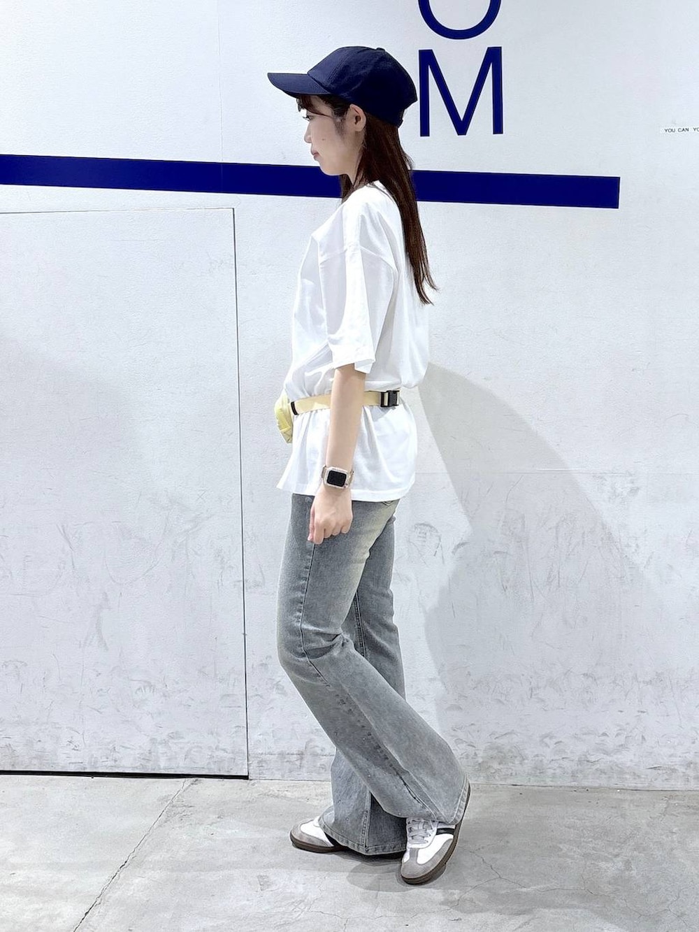 ベージュ系のボディバッグ/ウエストポーチ、ホワイト系のTシャツ/カットソー、ブルー系のデニムパンツを着用したレディースの夏コーディネートの3枚目の写真