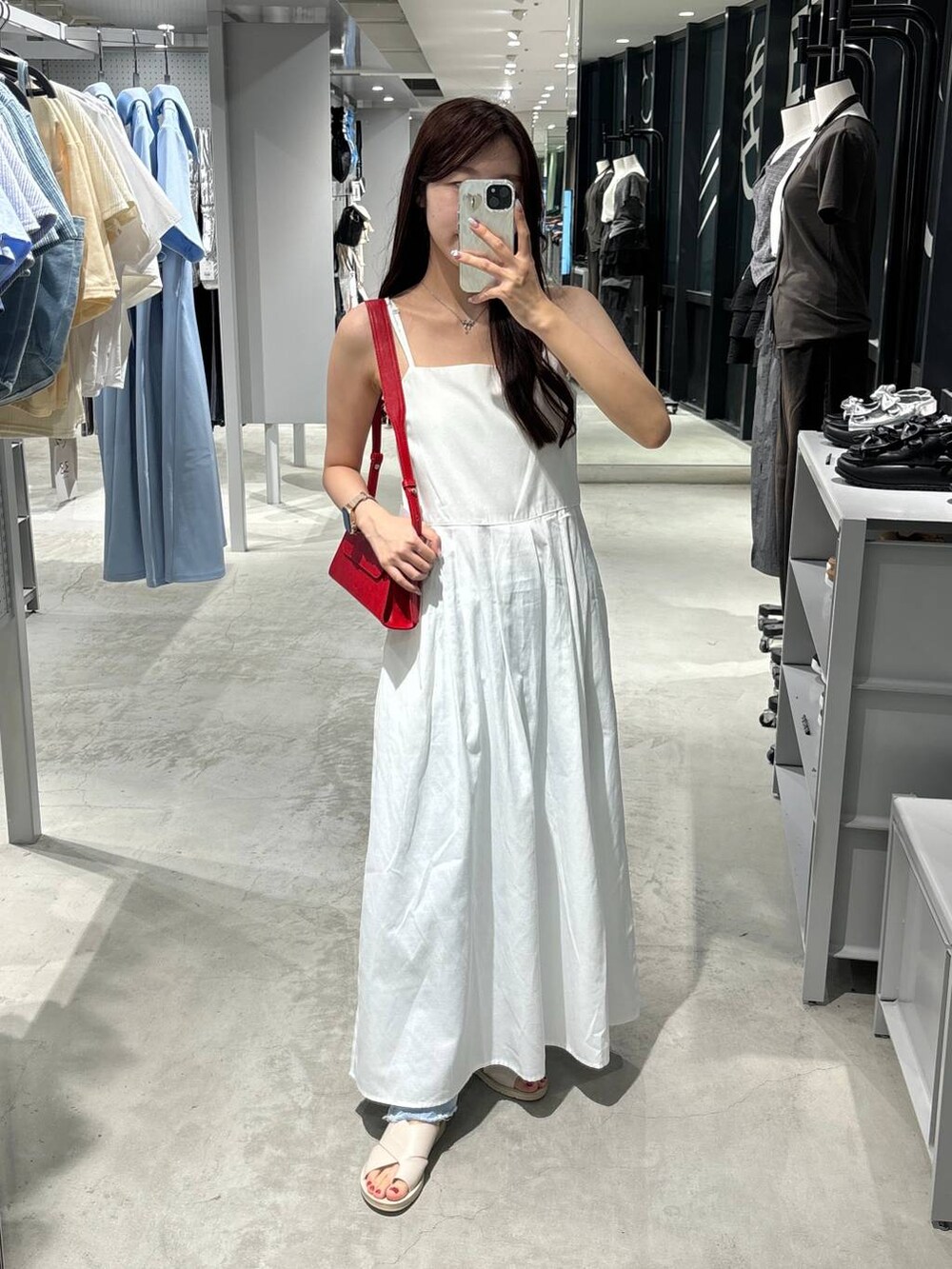 ホワイト系のワンピース、ベージュ系のサンダル、レッド系のショルダーバッグを着用したレディースの夏コーディネートの2枚目の写真