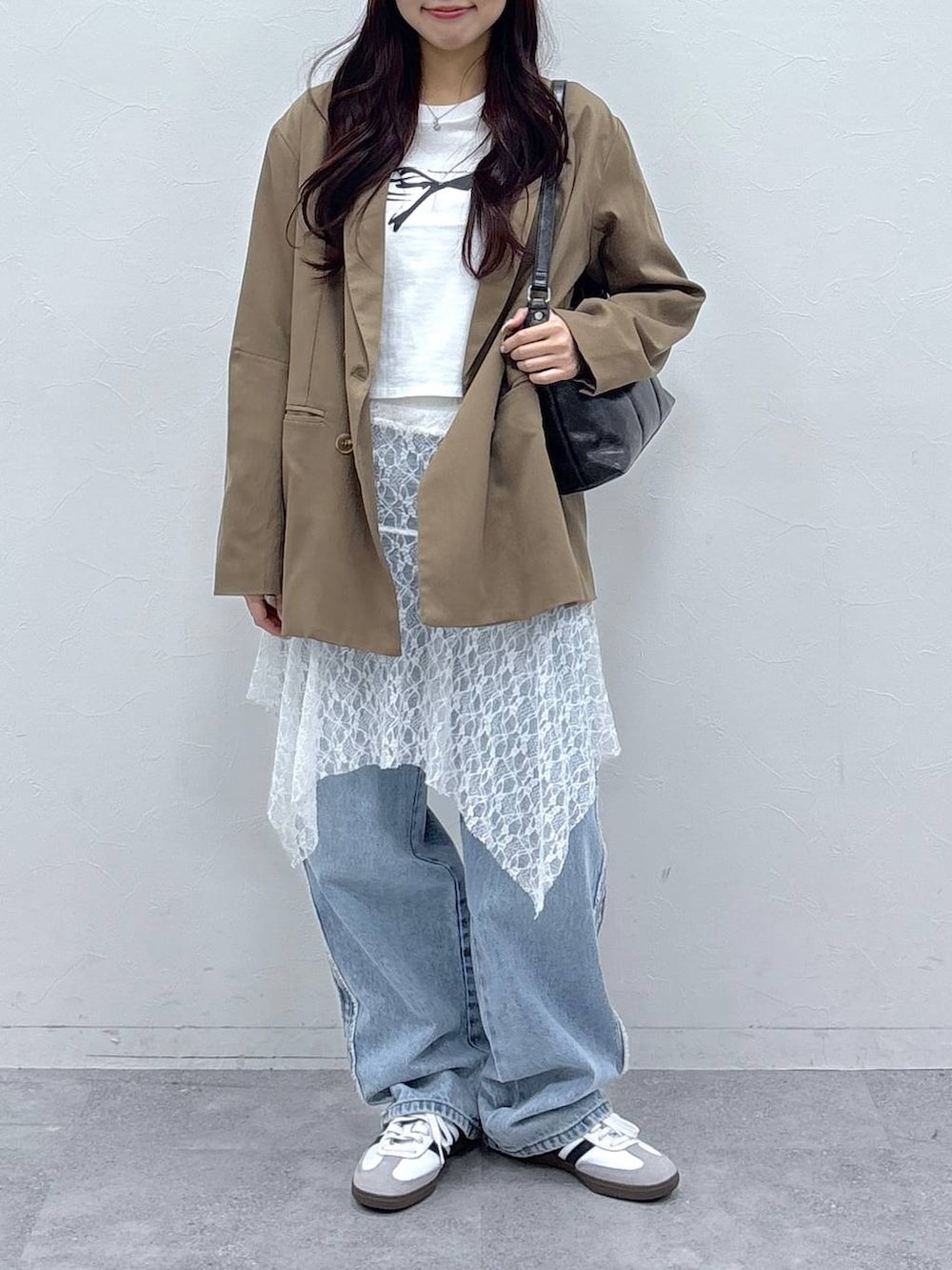 ブラウン系のテーラードジャケット、ホワイト系のスカート、ホワイト系のTシャツ/カットソーを着用したレディースの春コーディネートの2枚目の写真