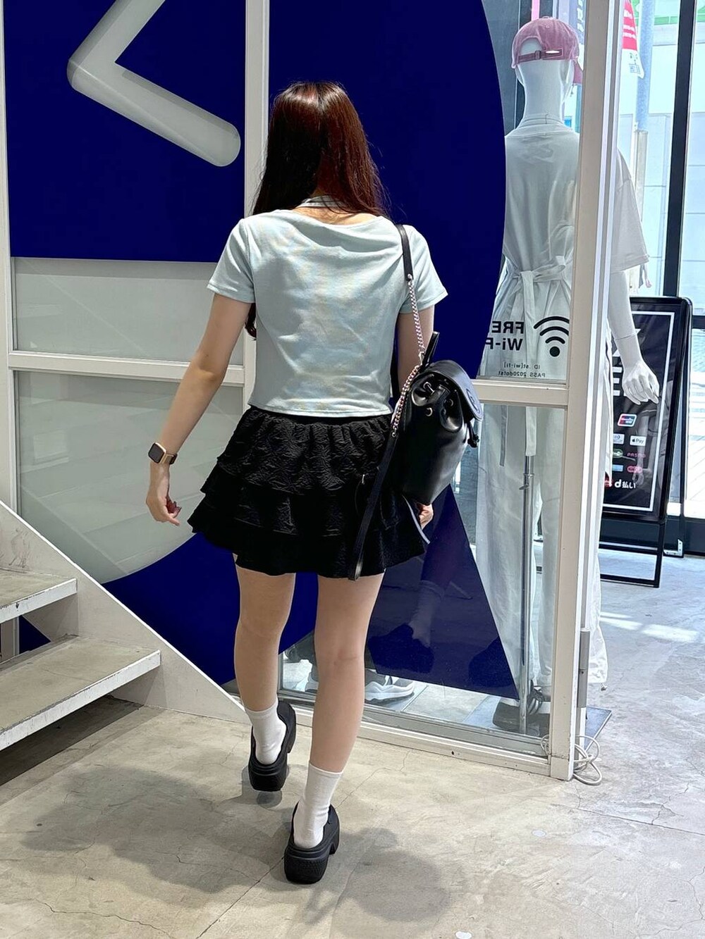 ブラック系のバックパック/リュック、ブルー系のTシャツ/カットソー、ブラック系のサンダルを着用したレディースの夏コーディネートの4枚目の写真