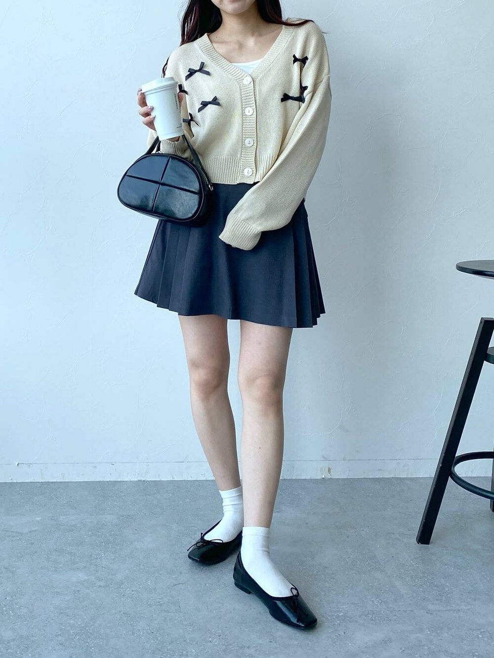グレー系のスカート、ベージュ系のカーディガン/ボレロを着用したレディースの春コーディネートの2枚目の写真