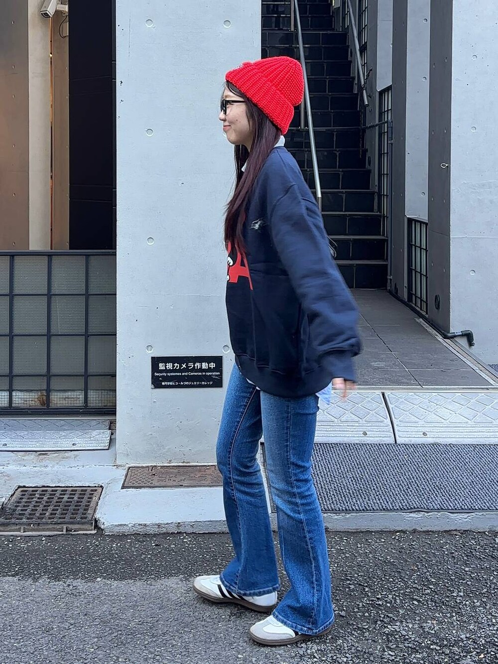 ブルー系のデニムパンツ、ブラック系のショルダーバッグ、ブルー系のスウェットを着用したレディースの冬コーディネートの3枚目の写真