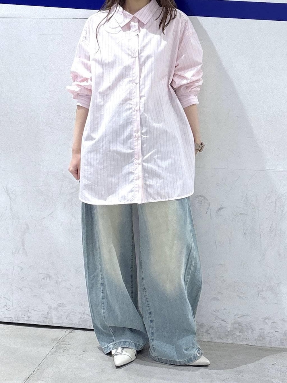 ブルー系のデニムパンツ、ホワイト系のパンプス、ピンク系のシャツ/ブラウスを着用したレディースの春コーディネートの2枚目の写真