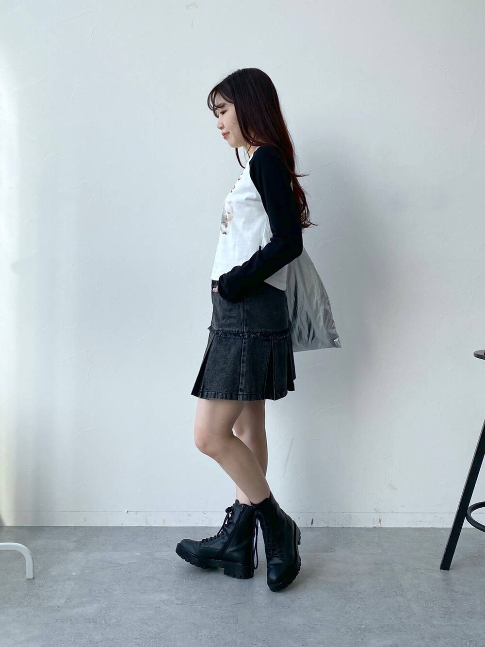 グレー系のトートバッグ、ホワイト系のTシャツ/カットソー、ブラック系のデニムスカートを着用したレディースの春コーディネートの3枚目の写真