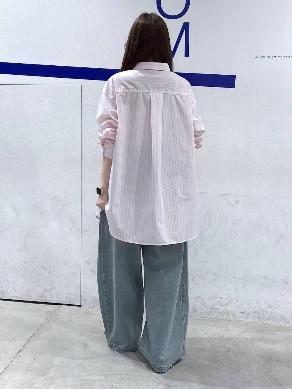 ブルー系のデニムパンツ、ホワイト系のパンプス、ピンク系のシャツ/ブラウスを着用したレディースの春コーディネートの4枚目の写真