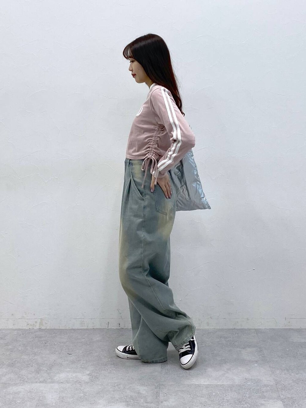 ブルー系のデニムパンツ、ピンク系のTシャツ/カットソー、グレー系のトートバッグを着用したレディースの春コーディネートの3枚目の写真
