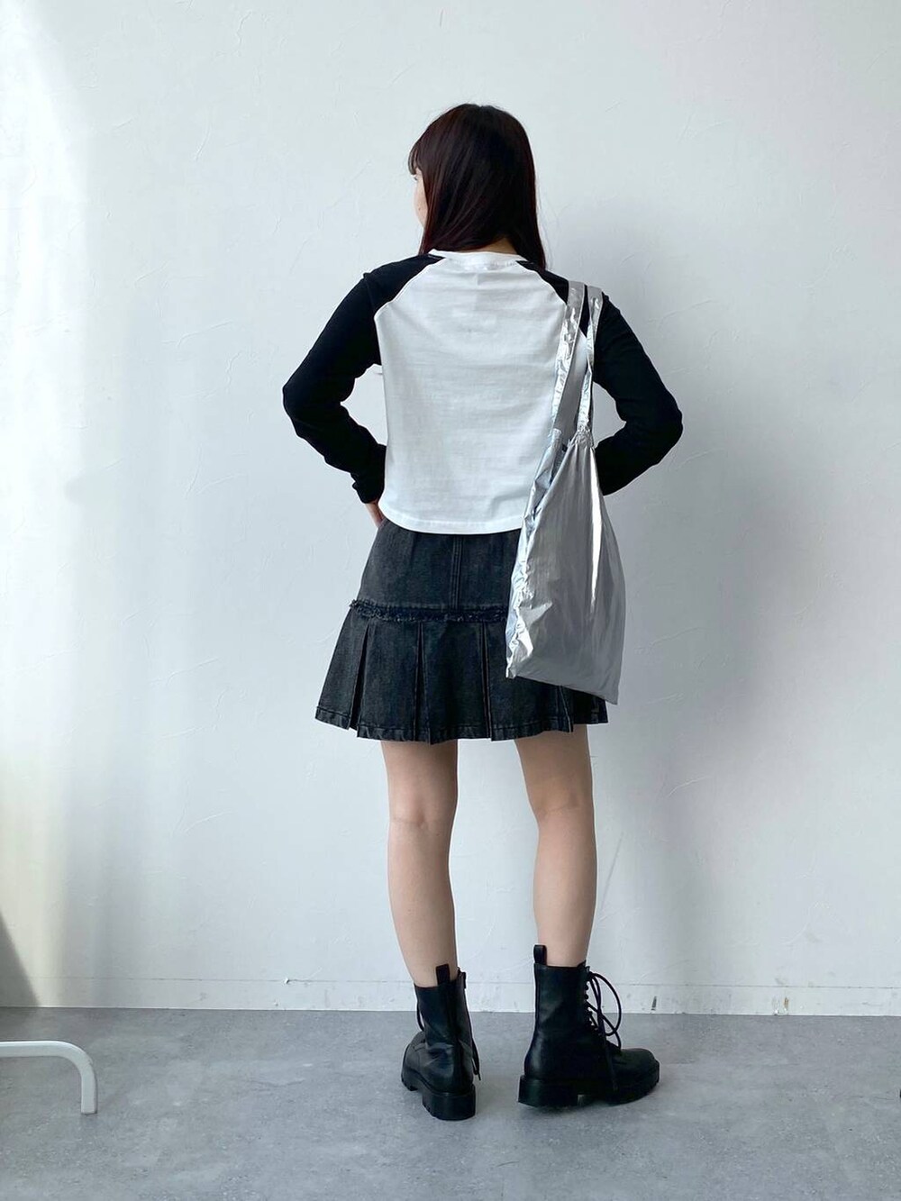 グレー系のトートバッグ、ホワイト系のTシャツ/カットソー、ブラック系のデニムスカートを着用したレディースの春コーディネートの4枚目の写真