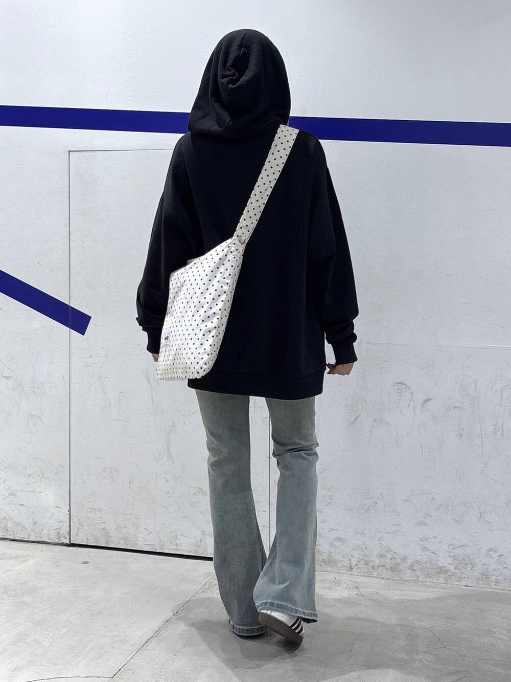 その他のトートバッグ、ブルー系のデニムパンツ、ブラック系のパーカーを着用したレディースの秋コーディネートの4枚目の写真