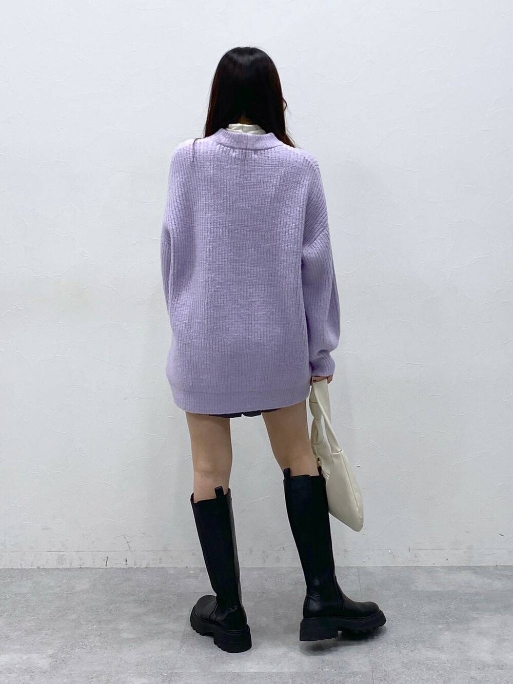 ブラック系のブーツ、パープル系のニット/セーター、ベージュ系のTシャツ/カットソーを着用したレディースの冬コーディネートの5枚目の写真