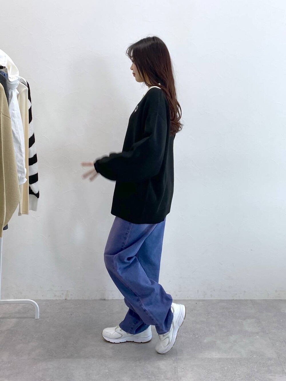 パープル系のデニムパンツ、ブラック系のニット/セーターを着用したレディースの冬コーディネートの4枚目の写真