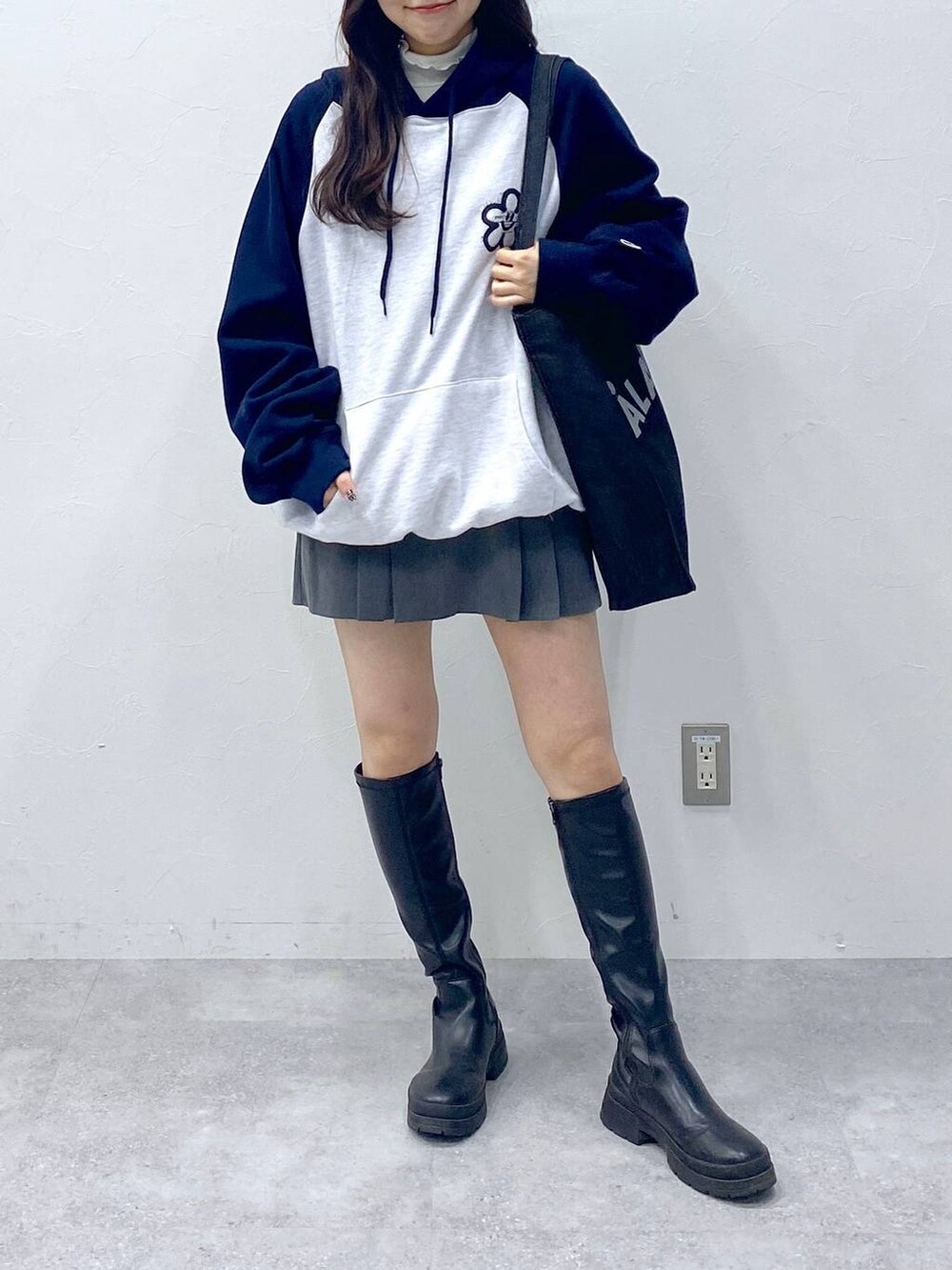 グレー系のスカート、ブルー系のトートバッグ、ブルー系のパーカーを着用したレディースの冬コーディネートの2枚目の写真