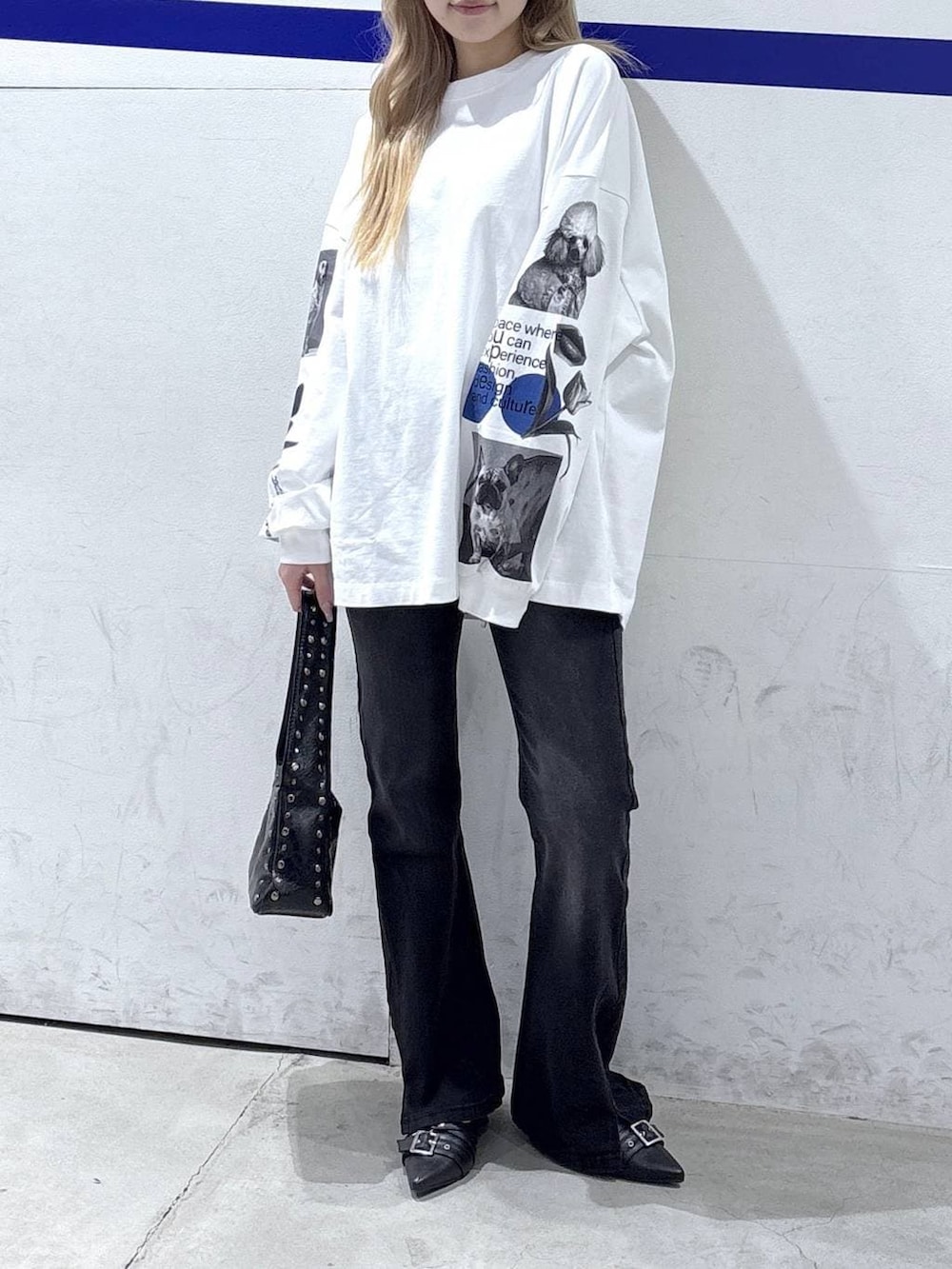 ブラック系のハンドバッグ、ブラック系のデニムパンツ、ブラック系のパンプスを着用したレディースの冬コーディネートの2枚目の写真