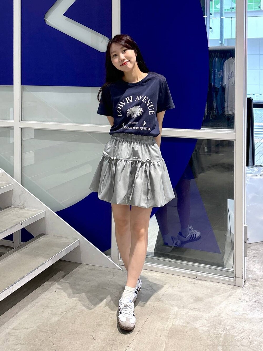 グレー系のスカート、ブルー系のTシャツ/カットソーを着用したレディースの夏コーディネートの2枚目の写真