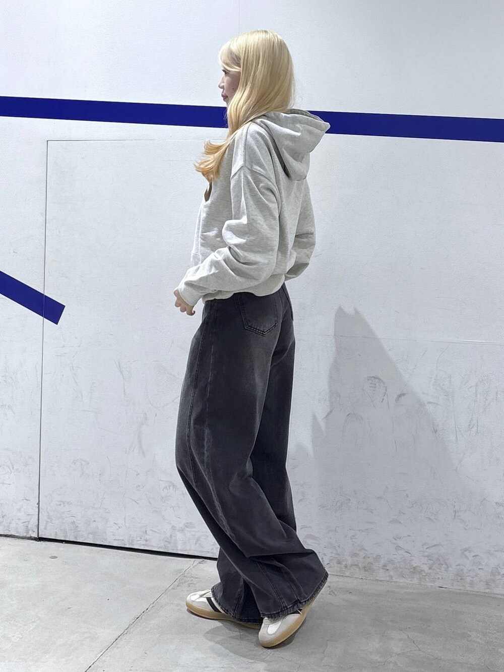 ブラック系のデニムパンツ、ベージュ系のパーカーを着用したレディースの秋コーディネートの2枚目の写真