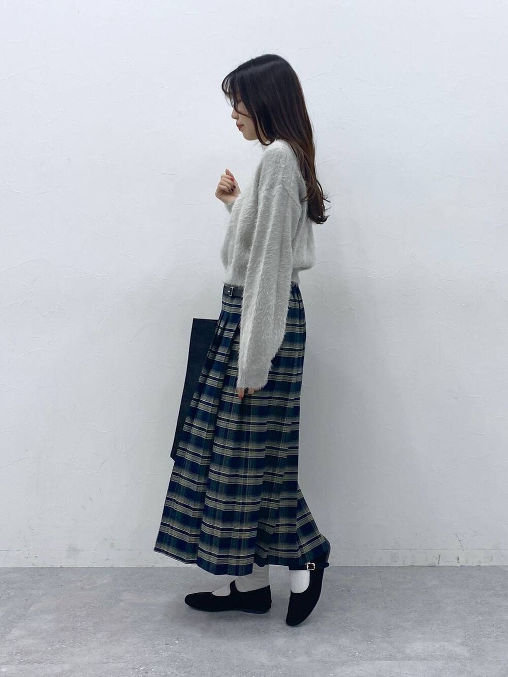 ブラック系のパンプス、ベージュ系のTシャツ/カットソー、ブルー系のスカートを着用したレディースの冬コーディネートの3枚目の写真