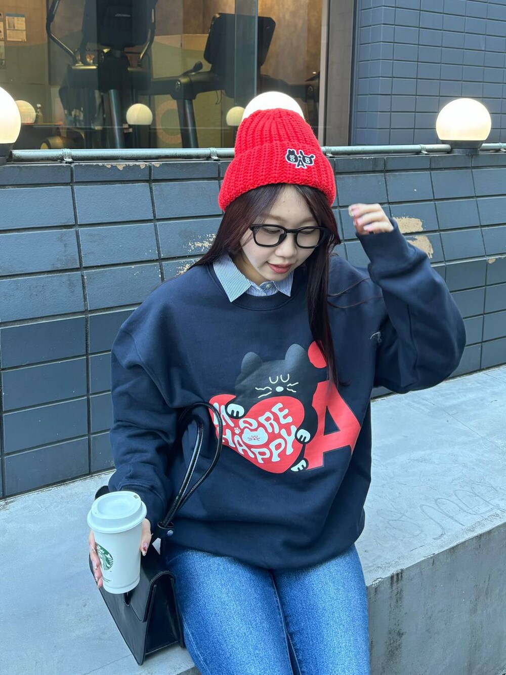 ブルー系のデニムパンツ、ブラック系のショルダーバッグ、ブルー系のスウェットを着用したレディースの冬コーディネートの7枚目の写真