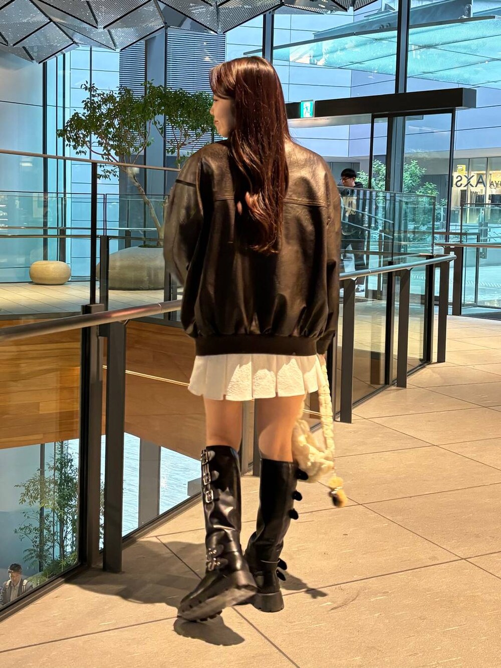 ブラウン系のライダースジャケット、ホワイト系のショルダーバッグ、グレー系のカーディガン/ボレロを着用したレディースの秋コーディネートの6枚目の写真