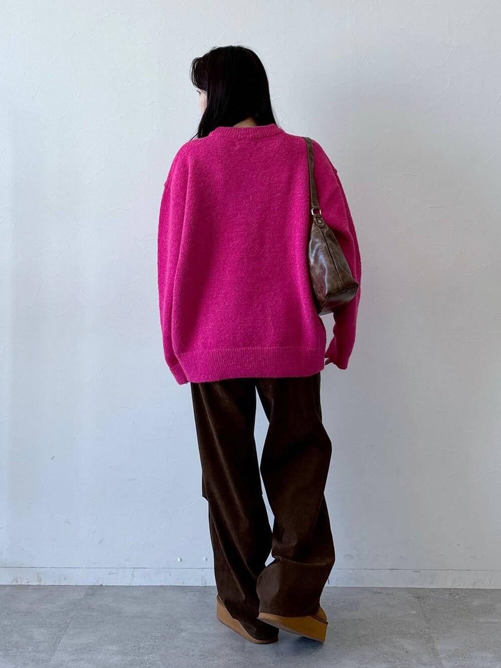 ブラウン系のその他パンツ、ブラウン系のハンドバッグ、ピンク系のニット/セーターを着用したレディースの冬コーディネートの4枚目の写真