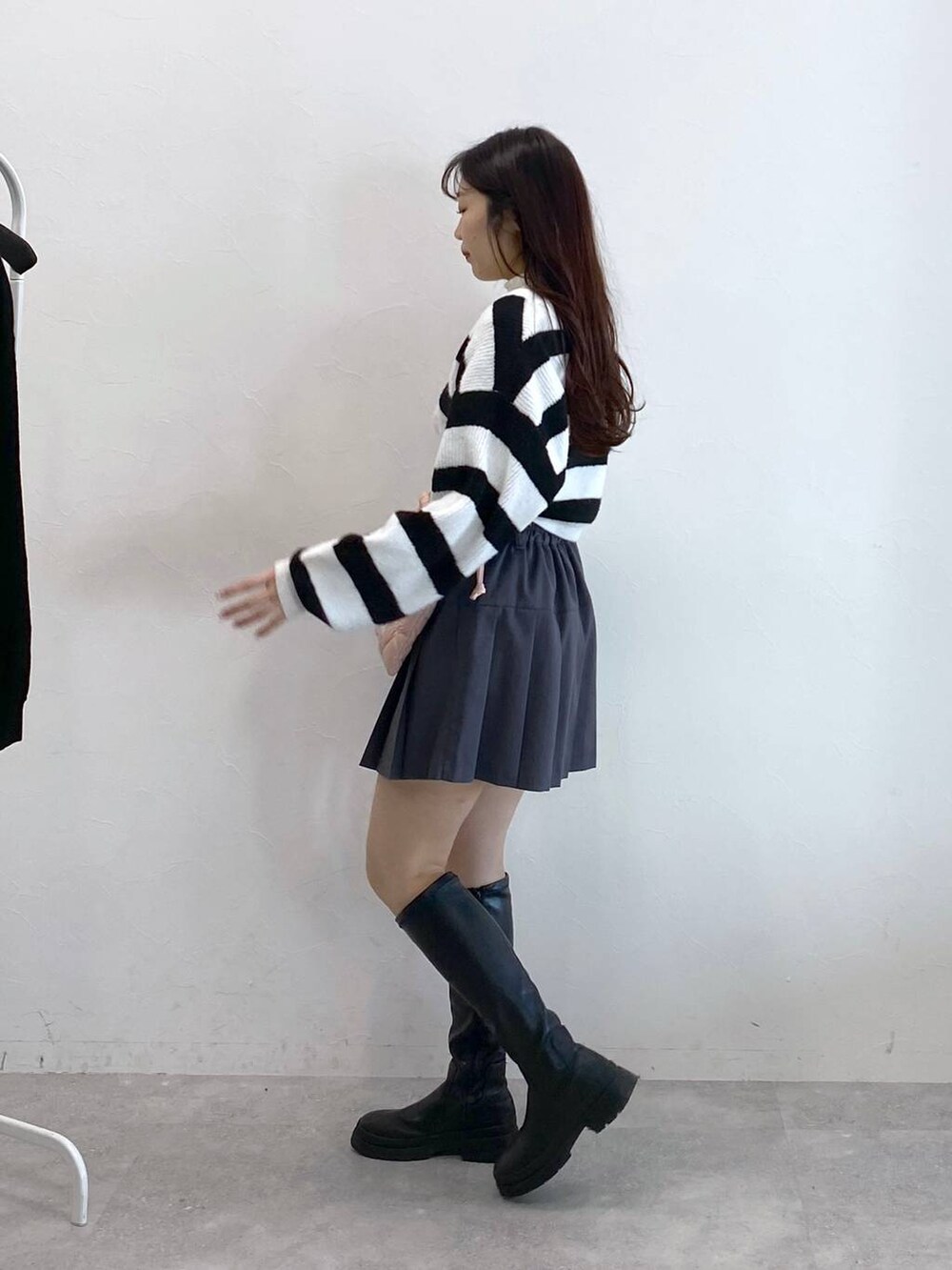 ピンク系のショルダーバッグ、ベージュ系のTシャツ/カットソー、グレー系のスカートを着用したレディースの冬コーディネートの3枚目の写真