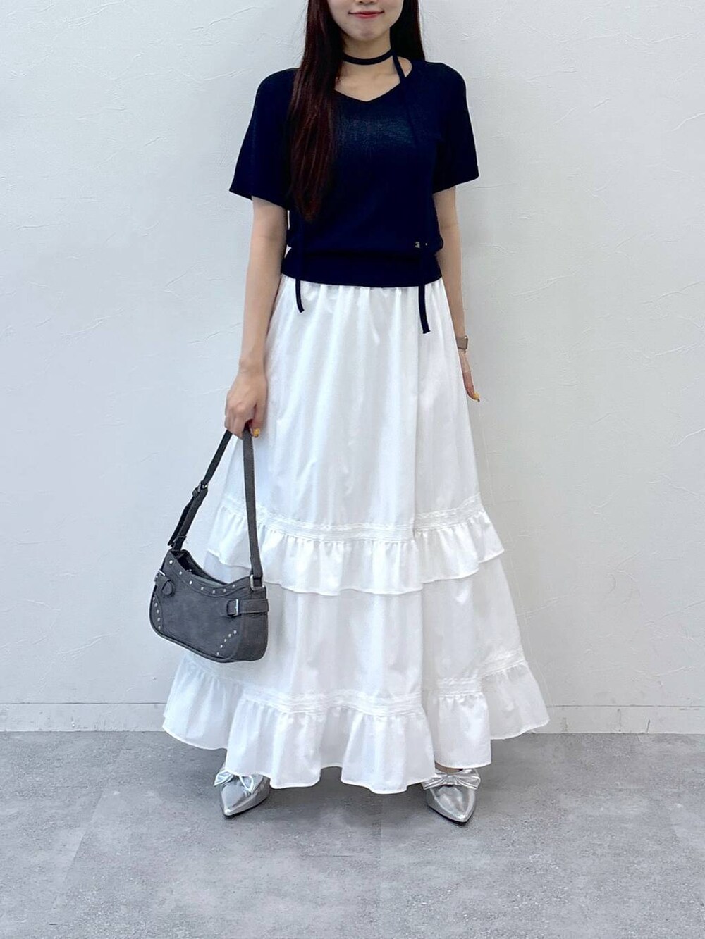 ホワイト系のスカート、ブラック系のトートバッグ、その他のサンダルを着用したレディースの夏コーディネートの2枚目の写真