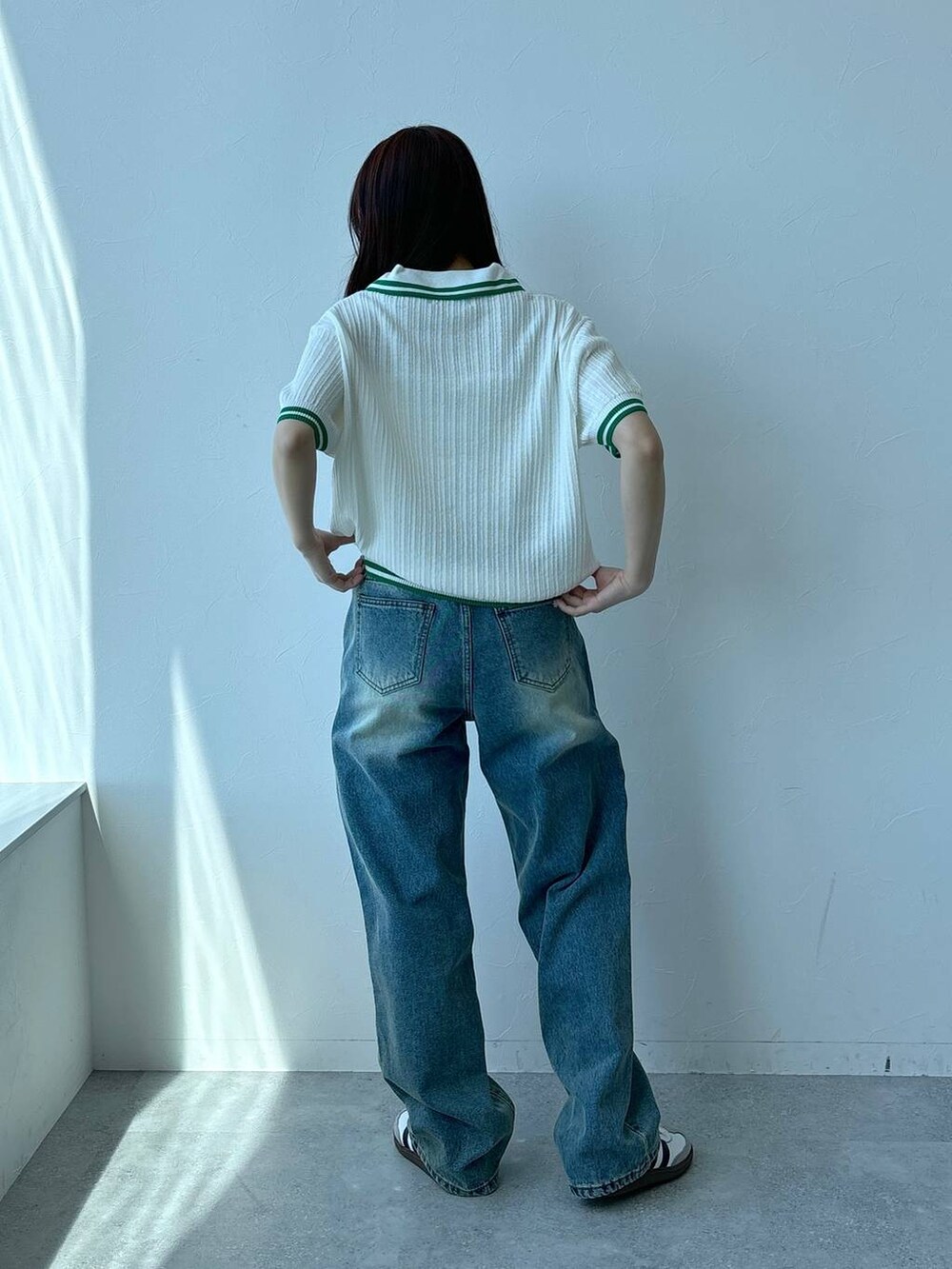 ベージュ系のニット/セーター、ブルー系のデニムパンツを着用したレディースの春コーディネートの4枚目の写真